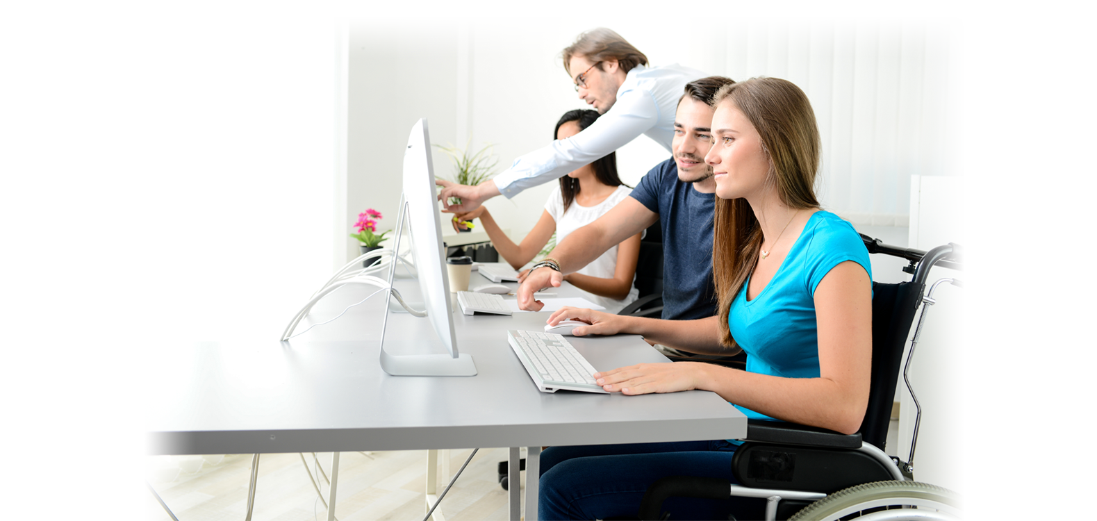 group of young people working in a computer lab, one in a wheelchair